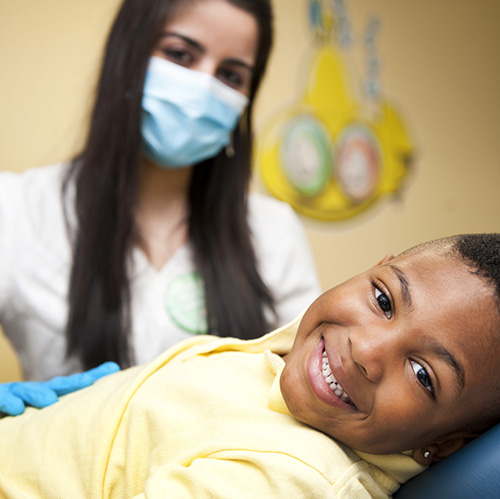 boy smiling with dentist in chair