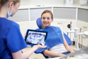 dentist showing xrays to teen in dentist office