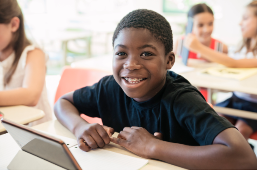 boy with braces smiling at desk
