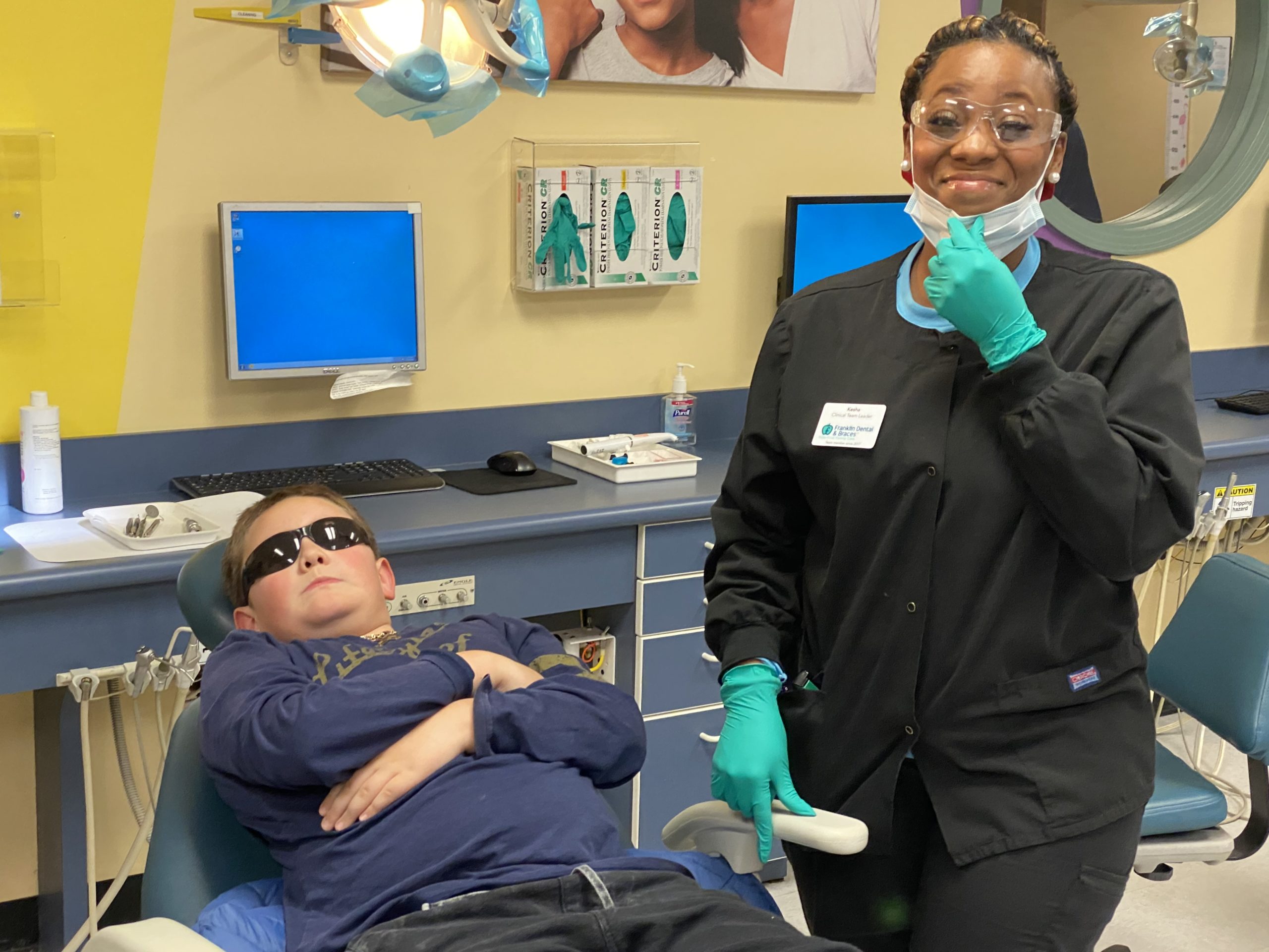 dentist smiling with boy in shades