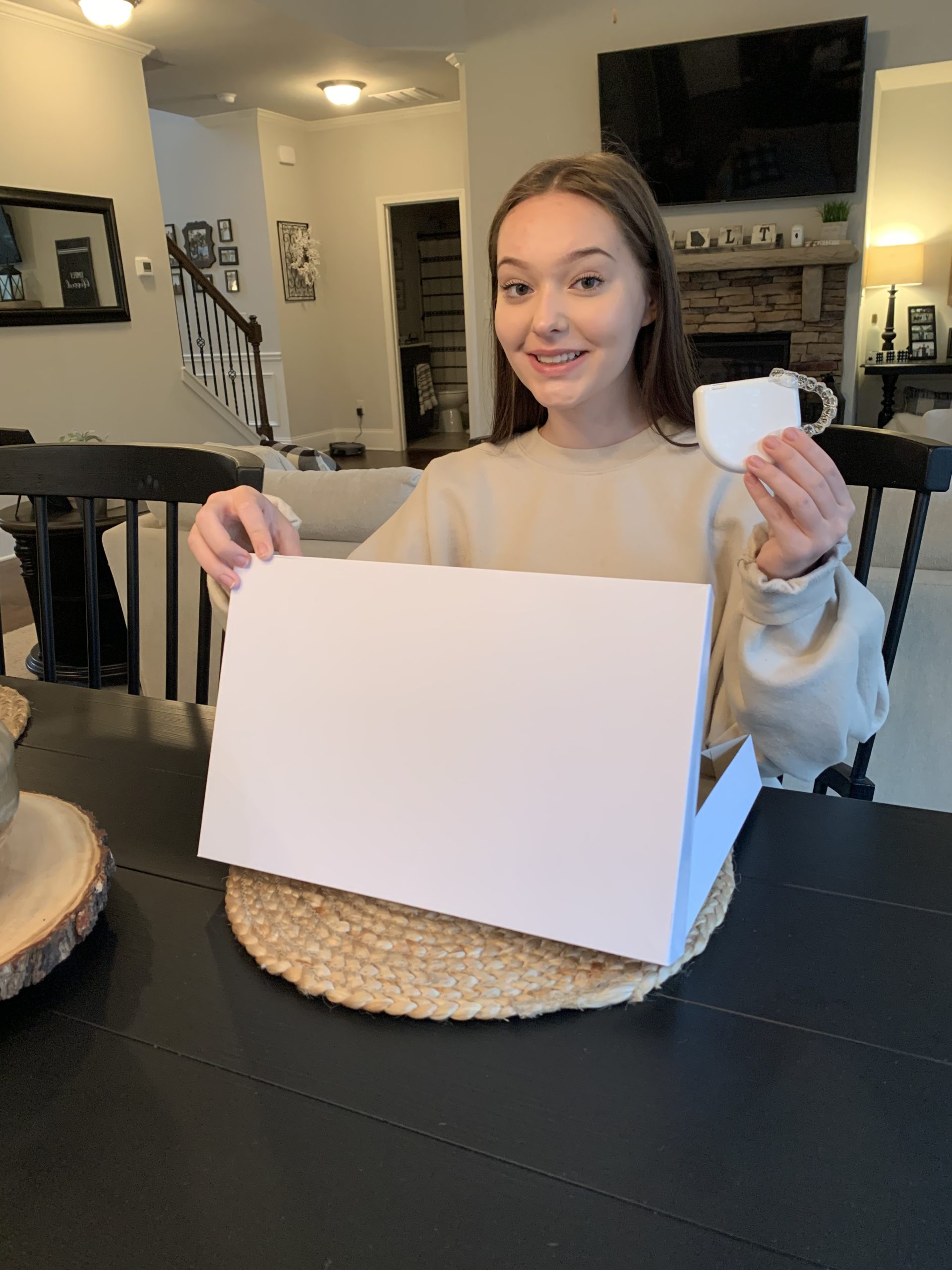 teenage girl holding clear braces and case