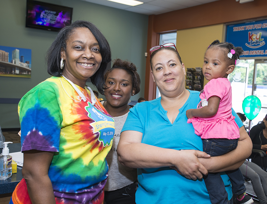 group of mothers smiling while holding child